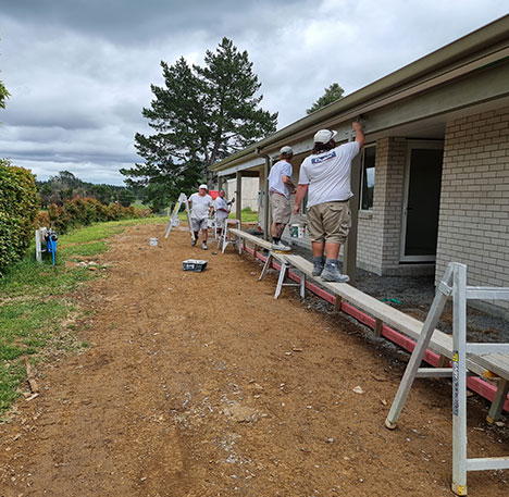 Professional painter safely working on residential roof